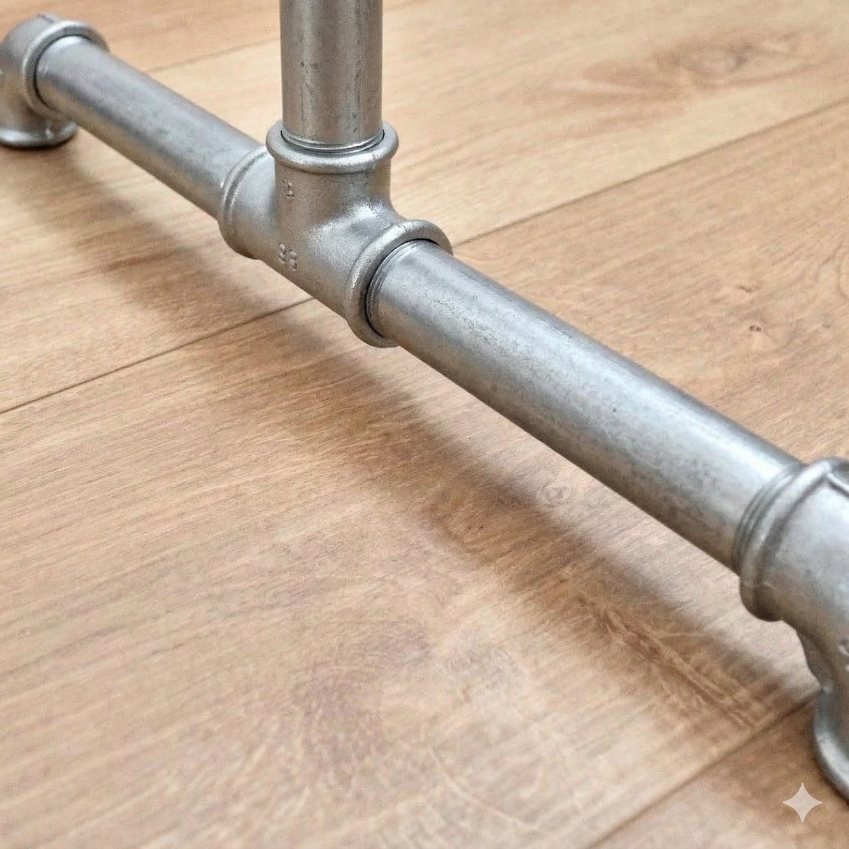 Détail du pied du portant galvanisé avec raccords en fonte et tubes filetés